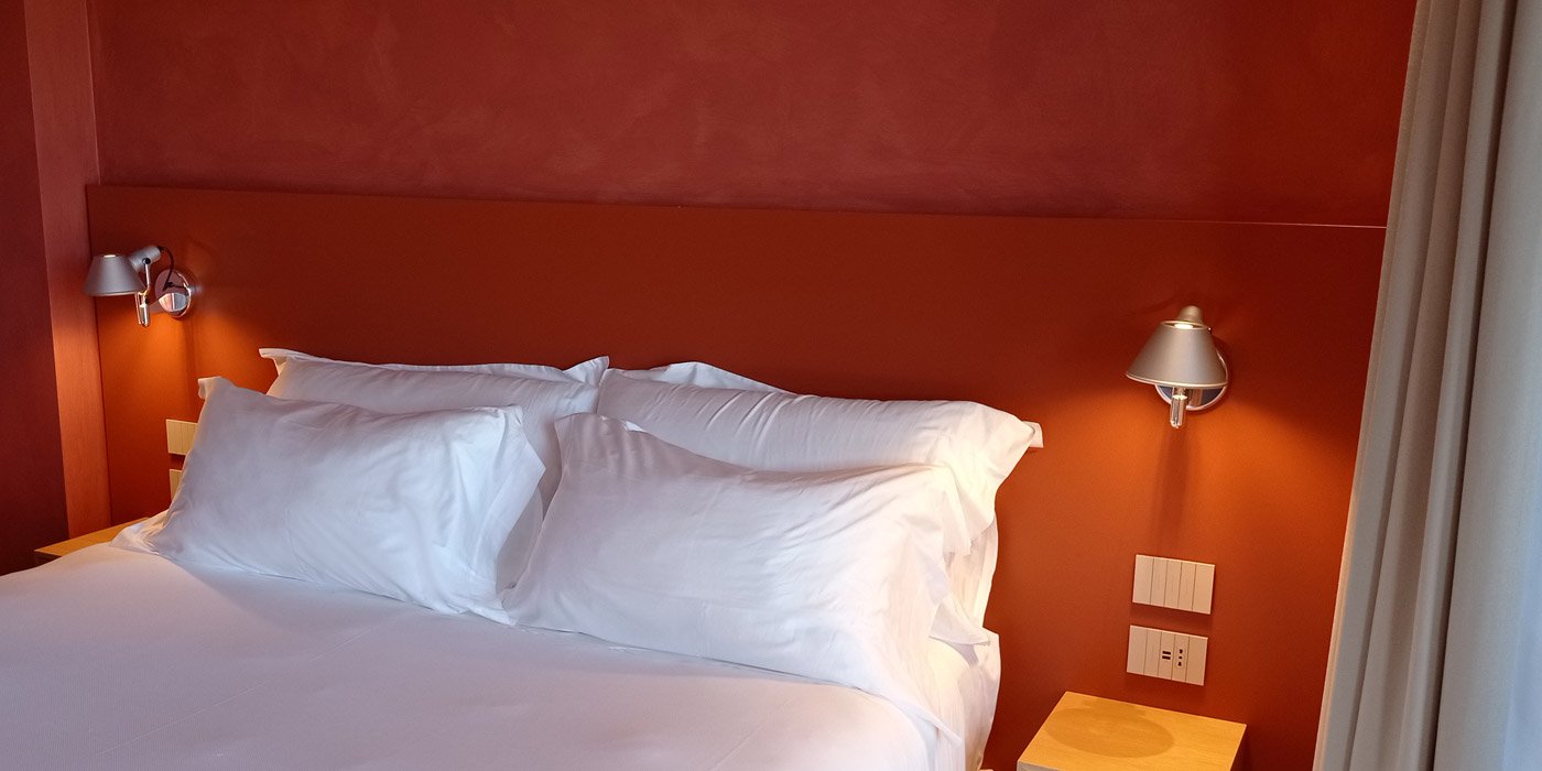 La Roqqa | Porto Ercole | Doppelbett im Zimmer mit Farbton Terra di Siena | luxuszeit.com